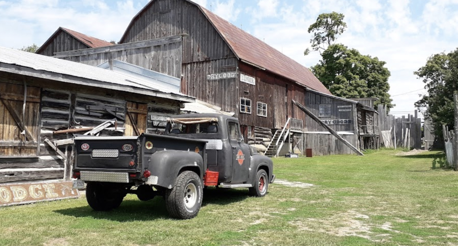 Vintage pickup truck parked in front of farmhouse.